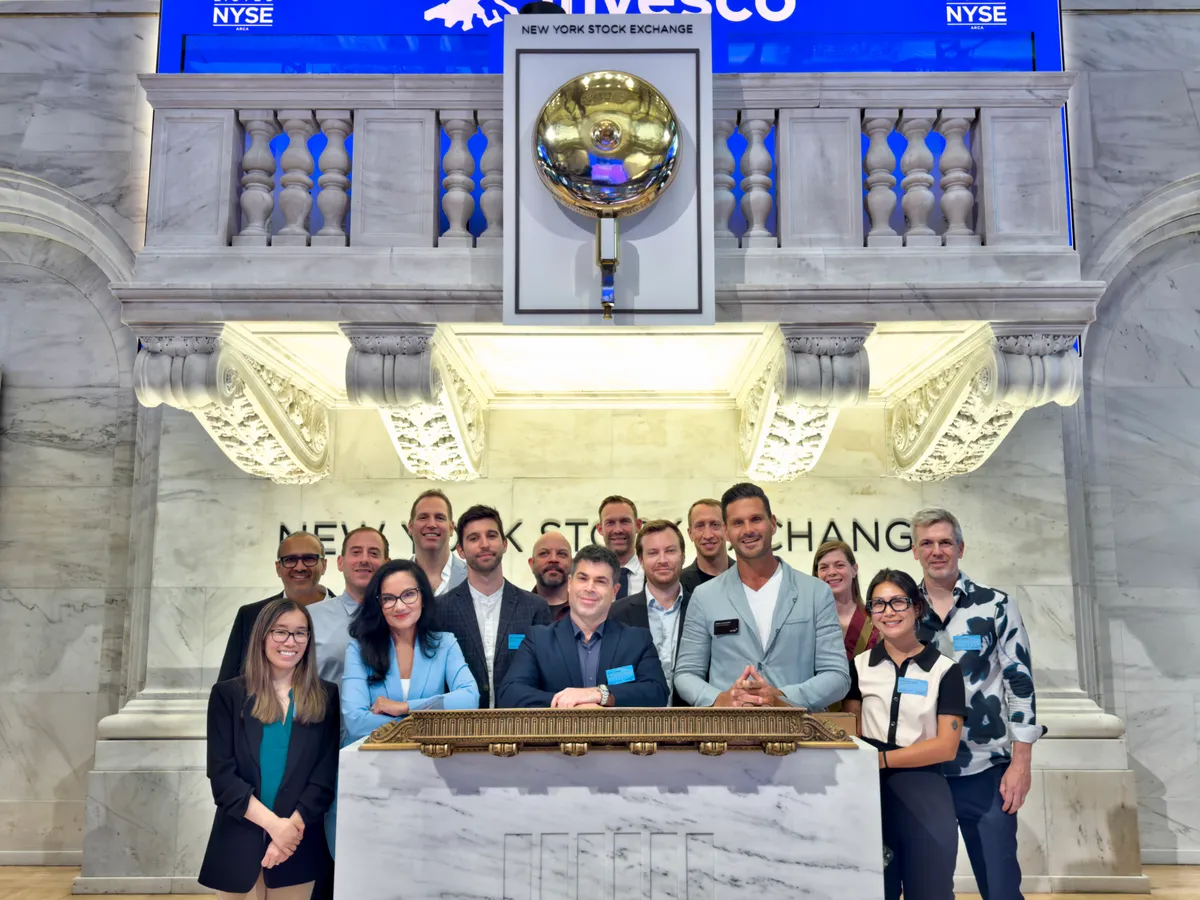Group photo on the New York Stock Exchange trading floor beneath the iconic bell. Jesse Robbins, center front. NYSE team: Judy Khan Shaw and Brian Baumann. Founders: Nick Patrick (Radar), Benjie De Groot (Shipyard), Mario Tarabbia (PartnerPage), Mike Long (Kosli), and Eden Full Goh (Mobot). Brady Forrest (GenLab). Andrea Echstenkamper and Mina Benothman.